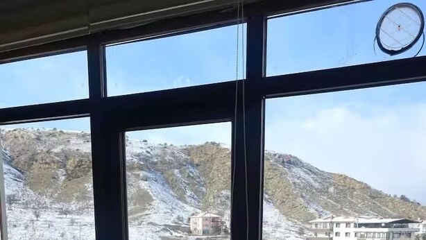 A room with large windows offering a view of a snowy landscape and a building. - Alacaatlı Suit (Ankara)