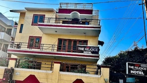 A multi-story hotel with a sign reading "The Rejoice Hotel". - GoBravo 842 Rejoice Hotel Gurgaon (Gurugram)