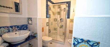 A bathroom with a sink, toilet, and shower.