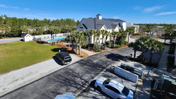 A residential area with a large house, a swimming pool, and a well-maintained lawn.