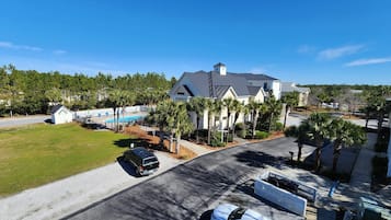 A residential area with a large house, a swimming pool, and a well-maintained lawn.