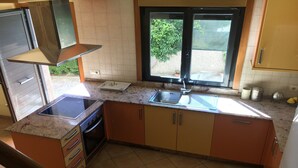 A kitchen with a stove, sink, and window. - Apartment in Cangas near Playa de Barra (Cangas do Morrazo)