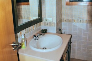 Ein Badezimmer mit Waschbecken, Spiegel und gefliesten Wänden.