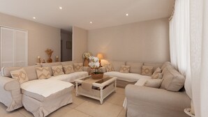 A modern living room with a sectional sofa, a glass-top coffee table, and a side table with a lamp. - Villa 'Soleil Et Douceur' with Private Pool, Wi-Fi and Air Conditioning (La Seyne-sur-Mer)