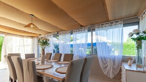 A dining area with a table set for six, surrounded by chairs, under a canopy. - Villa 'Soleil Et Douceur' with Private Pool, Wi-Fi and Air Conditioning (La Seyne-sur-Mer)