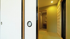 Un pasillo con puerta de madera y ventanal circular.