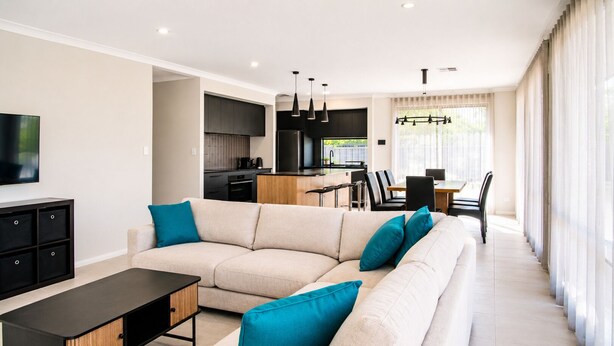 A modern living room with a sofa, a coffee table, and a TV. - Sunset Shores (Busselton)