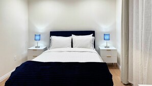 A neatly arranged bedroom with a bed, two bedside tables, and a nightstand. - Chic studio with AC / WiFi and Garden in marvelous West Covina (West Covina)