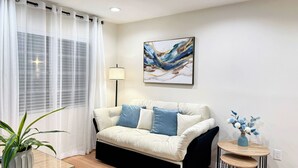 A modern living room with a sofa, a lamp, a painting, and a small table with a vase. - Chic studio with AC / WiFi and Garden in marvelous West Covina (West Covina)