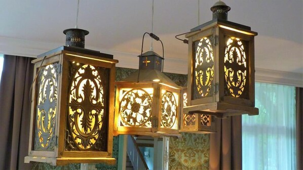 Tres lámparas ornamentales con diseños intrincados recortados, suspendidas del techo.