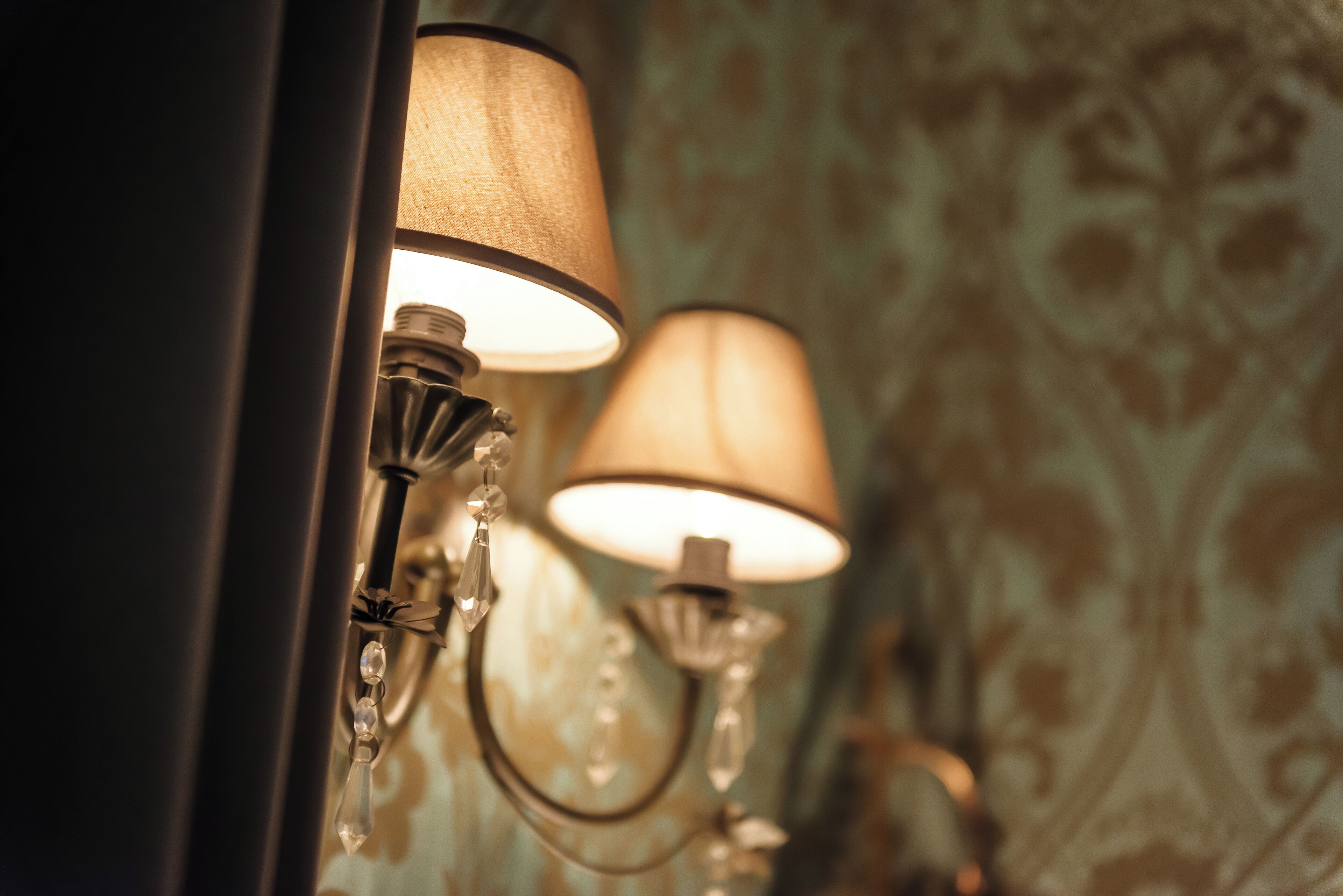 A wall-mounted lamp with a cylindrical shade and a curved design.