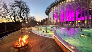 Een zwembadgedeelte met meerdere jacuzzi's en een vuurplaats.