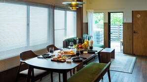 A dining area with a table set for two, featuring a fruit bowl, plates, and glasses. - HOTEL RIN TOKYO (Tokyo)