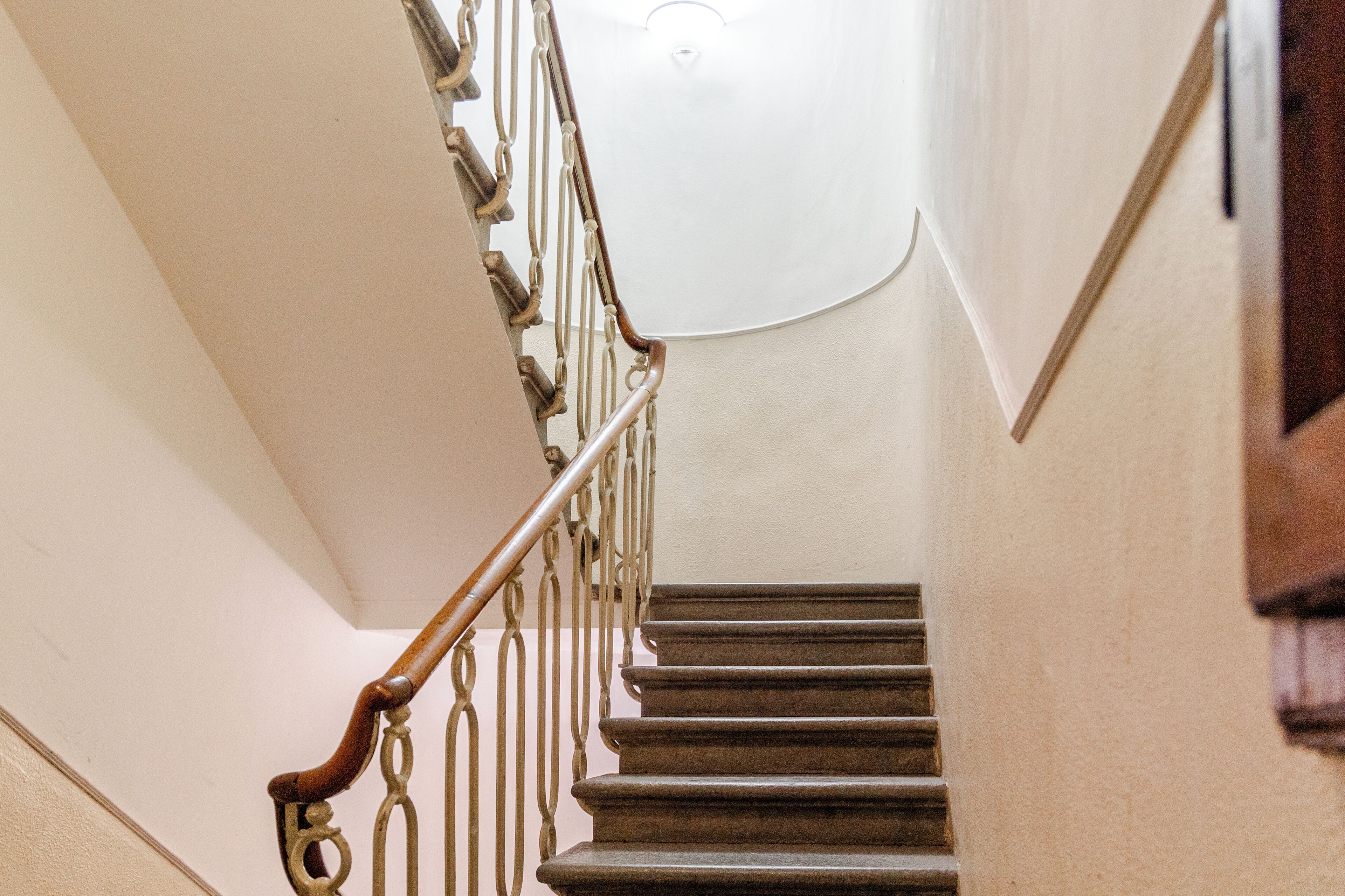 A staircase with wooden handrails and a light fixture at the top.