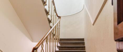 A staircase with wooden handrails and a light fixture at the top.