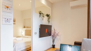 A modern hotel room with a bed, a laptop, a glass of wine, and a potted plant. - Elegant & Cozy Apartment Florence City Center (Firenze)