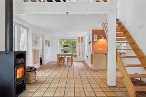 Ein modernes Interieur mit Kaminofen, Essbereich und Treppe.