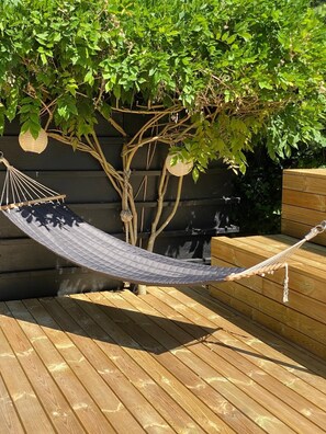 A hammock on a wooden deck with a tree and hanging lanterns. - Lovely summer house with a fantastic view (Knebel)
