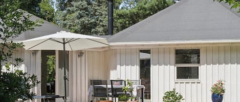 A house with a covered patio, outdoor furniture, and potted plants.