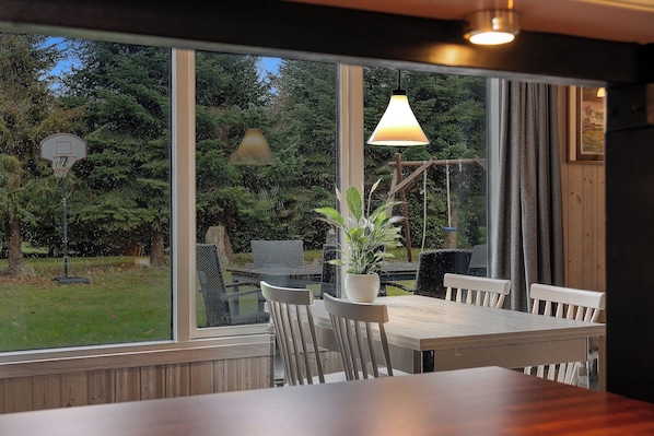 Un comedor con una mesa, sillas y una planta en maceta.