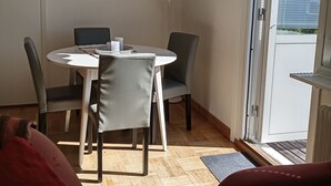 A dining area with a round table, chairs, and a decorative wall piece. - Holiday Home Bispgården (Bispgården)