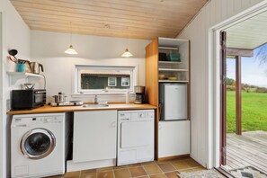 Una cocina compacta equipada con lavadora, microondas y refrigerador.
