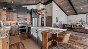 Una cocina amplia con una isla grande, armarios de madera y electrodomésticos modernos.
