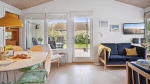 Un intérieur moderne comprenant un coin repas, un canapé et une vue sur le jardin.