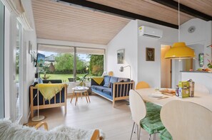 A modern living room with a sofa, coffee table, and dining area.