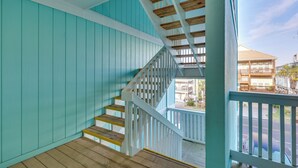 Ein türkisfarbenes Interieur mit einer Holztreppe, die zu einem Balkon führt.