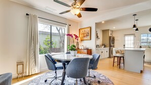 A modern kitchen with a central island, a dining area with a round table and chairs, and a large window with curtains. - Updated Home w/ Private Deck, 1 Mi to Rose Bowl! (Pasadena)