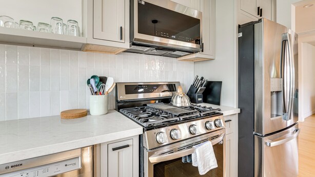 A modern kitchen with stainless steel appliances, including a Bosch dishwasher, a Bosch gas stove, and a refrigerator. - Updated Home w/ Private Deck, 1 Mi to Rose Bowl! (Pasadena)