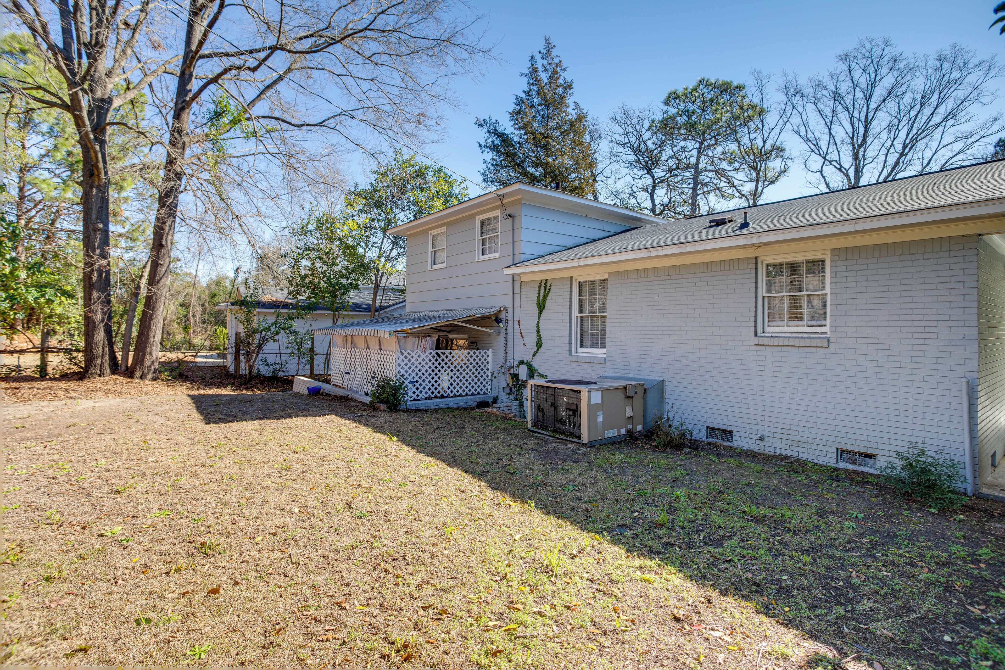 A two-story house with a fenced backyard, a covered porch, and a small detached garage.