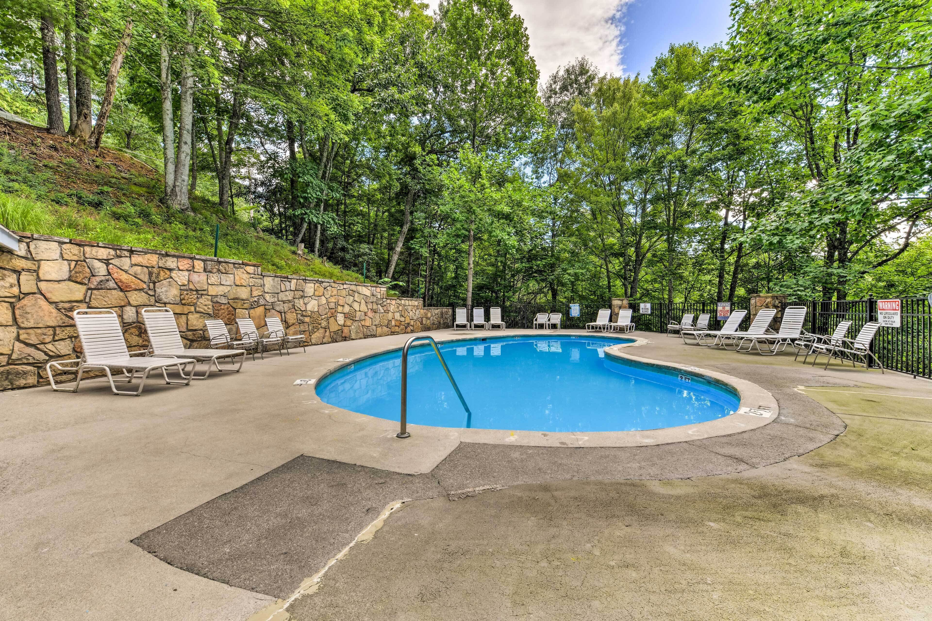Une piscine avec des chaises longues et un mur en pierre.