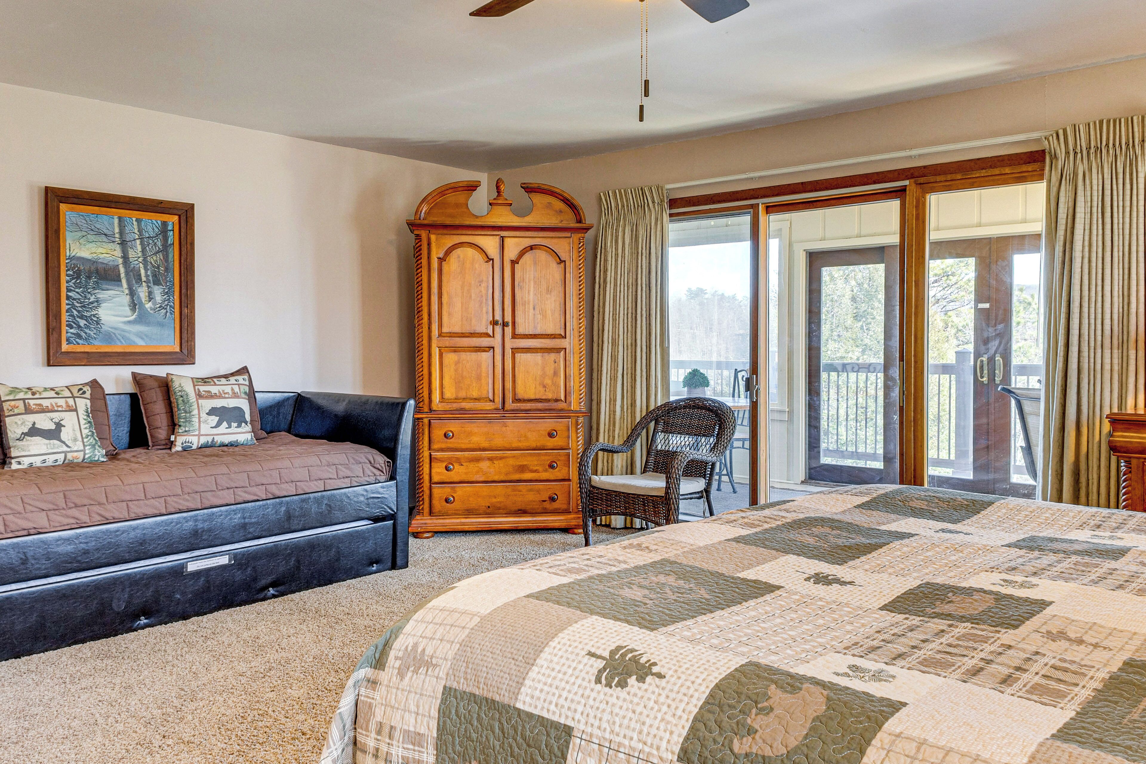 A bedroom with a large bed, a dresser, a chair, and a painting on the wall.