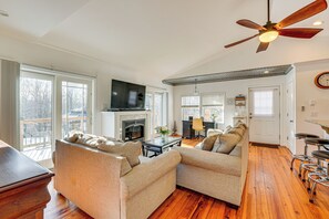 A spacious living room with a fireplace, a television, and a ceiling fan. - Hudson Valley Retreat w/ Pool Near Greenwood Lake (Monroe)