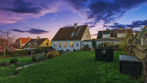 Un quartier résidentiel avec des maisons, une pelouse verdoyante et un ciel dégagé.