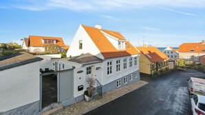 Une rue résidentielle bordée de maisons, avec un garage et un fourgon stationné.