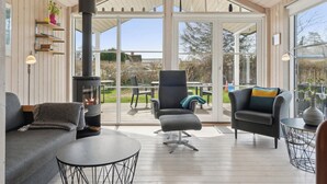 Un intérieur moderne avec une cheminée, un canapé, un fauteuil et une table.
