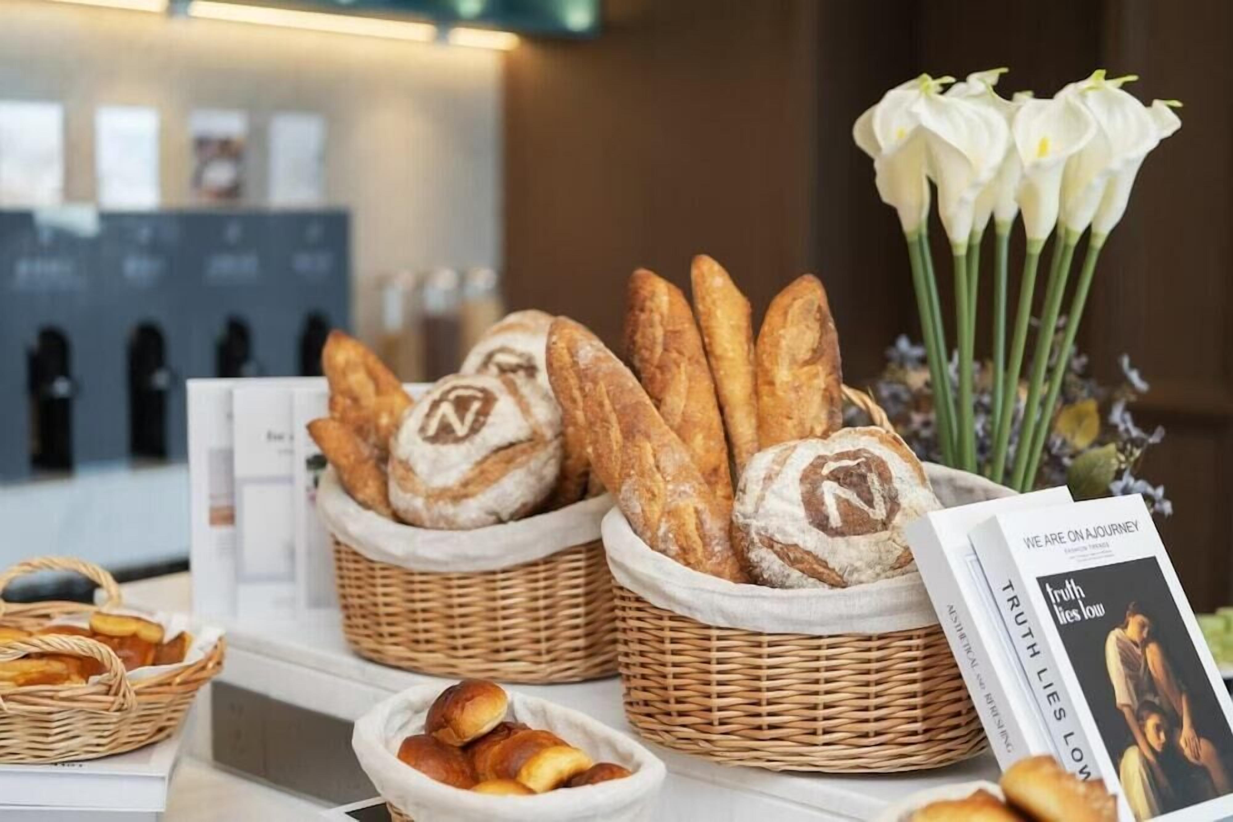 A display of bread baskets with a logo, a book titled 'Truth Lies Low,' and a bouquet of white flowers.