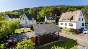 A residential area with houses, a wooden structure, and a paved road. - 'Urban' Apartment with Mountain View, Balcony & Wi-Fi – Tourist Use Only (Bestwig)