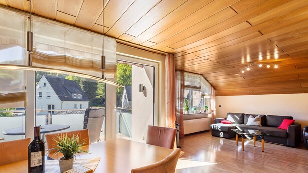 A modern interior with a dining area, sofa, and large windows. - 'Urban' Apartment with Mountain View, Balcony & Wi-Fi – Tourist Use Only (Bestwig)