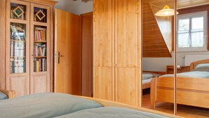 Una camera da letto con un'armadio in legno, un letto e una finestra.