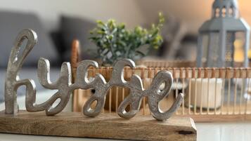 A decorative metal sign with the word 'hygge' on a wooden board.