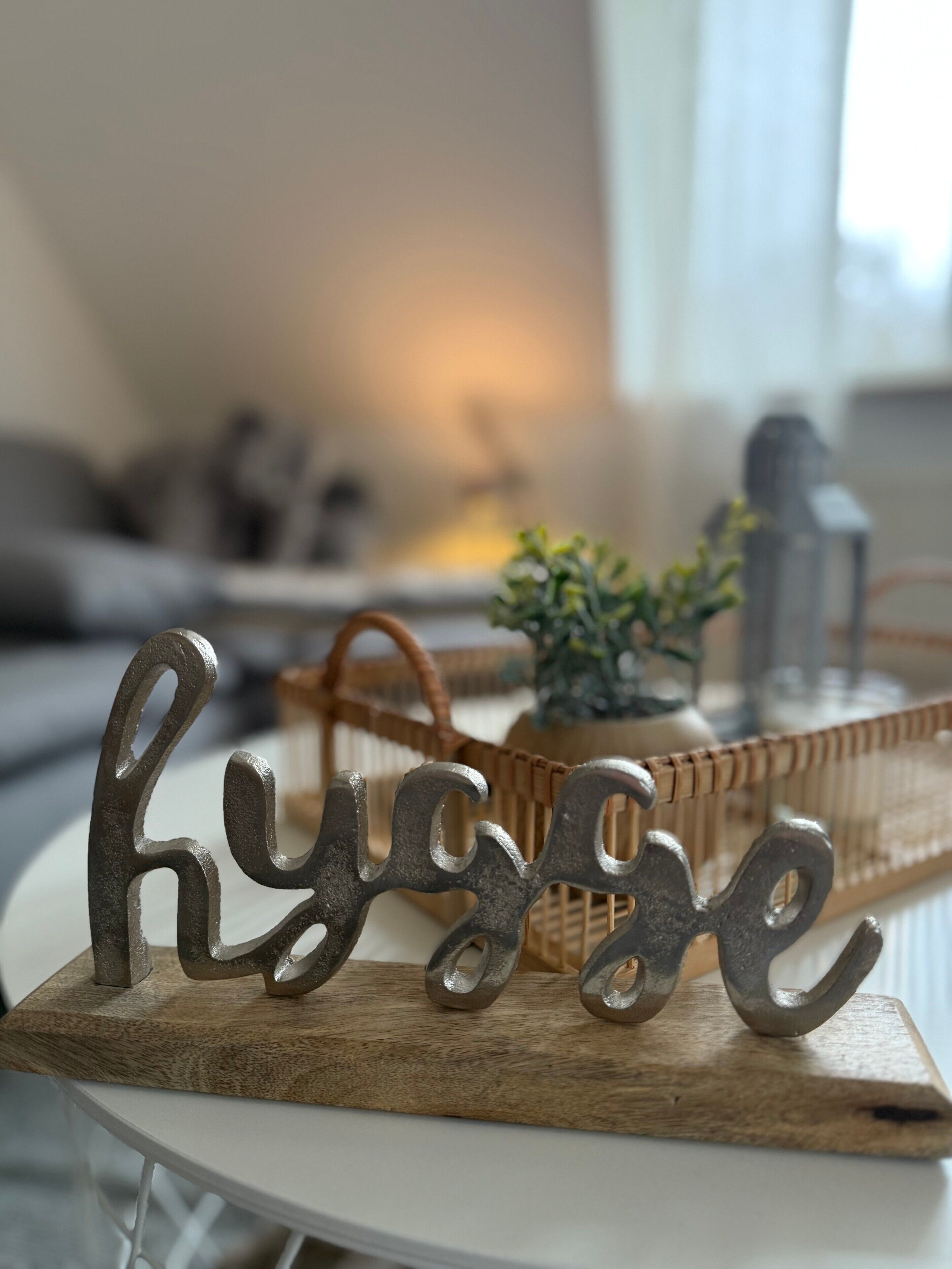 Een houten naambordje met de naam 'Hyge' op een witte tafel.