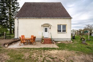 A single-story house with a tiled roof, a front door, and a small window.