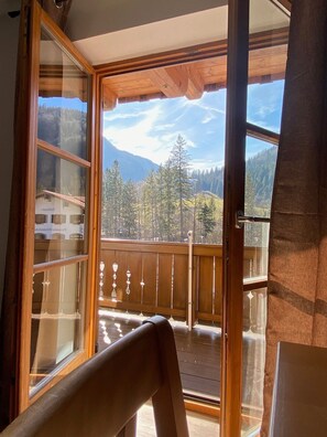 A wooden balcony with a view of a mountainous landscape.
