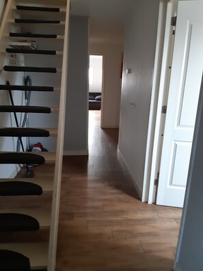 A staircase leading to a bedroom with a wooden floor and a white door.