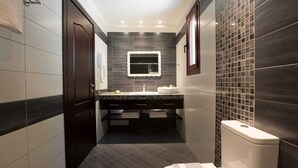 A modern bathroom with dark tiles, a vanity with a mirror, and a toilet. - Villa Magnolia Lefkada Greece (Lefkada)