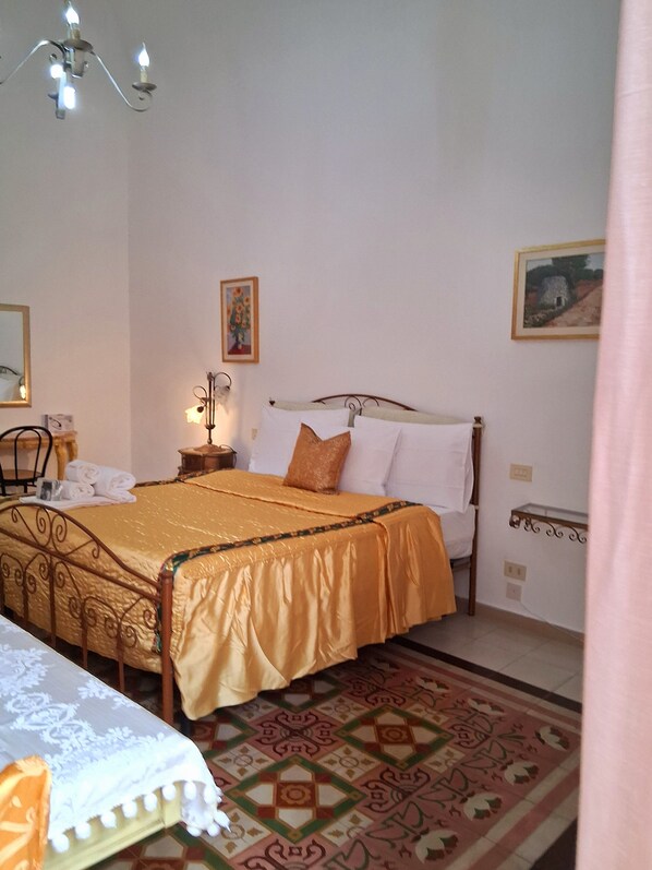 Ein Schlafzimmer mit einem Bett, einem Nachttisch, einer Lampe und einem Bild an der Wand.